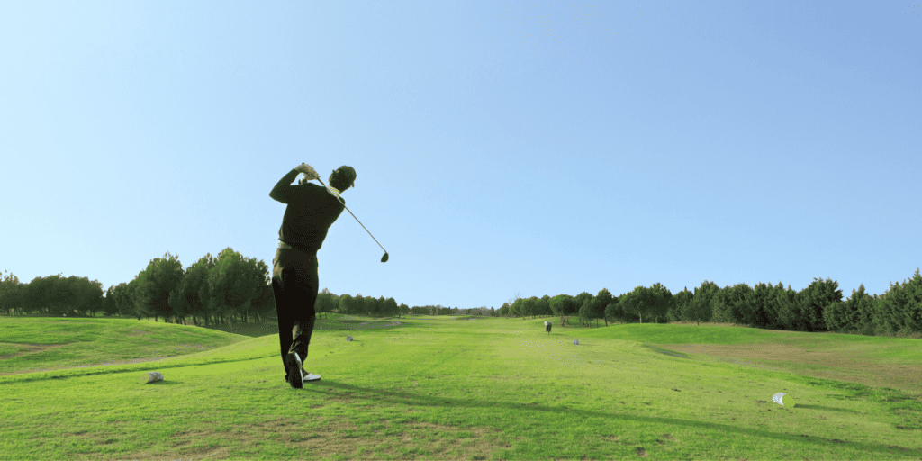A golfer taking a golf swing with a driver