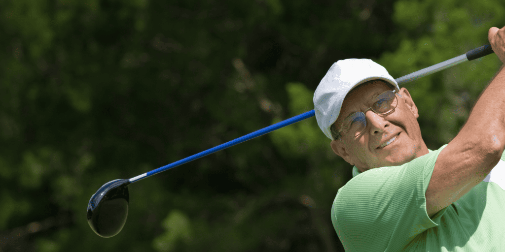 A senior golfer swinging a golf club