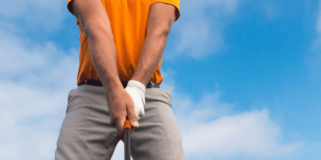 Golfer holding a golf club with a weak grip